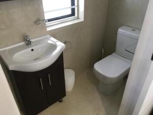 a bathroom with a sink and a toilet and a window at Sea La Vie in Jacobs Bay