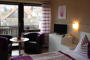 Habitación de hotel con cama, TV y ventana en Saaletal Pension & Ferienwohnungen, en Bad Bocklet