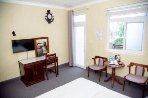 a room with a tv and a table and chairs at Ha Trinh Hotel in Bien Hoa