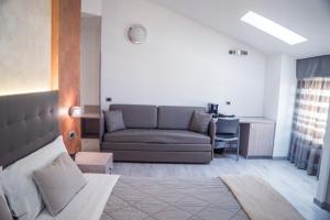 a living room with a couch and a desk at Hotel Gabbiano in Rimini
