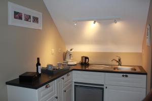 a kitchen with a sink and a counter top at A l'ombre du noyer in Fernelmont