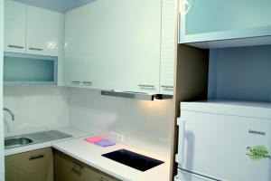 uma cozinha com armários brancos e um frigorífico branco em Studio NATASHA in the area of Kallithea em Atenas