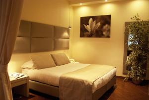 een slaapkamer met een bed en een schilderij aan de muur bij Il Portico Luxury B&B in Cassano delle Murge