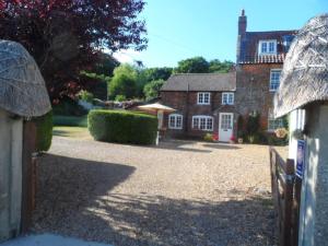 a large brick house with a driveway in front of it at Stunning 3 bedroom self catering cottage near Stonehenge, Salisbury, Avebury and Bath All bedrooms ensuite in Pewsey