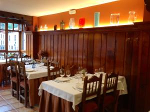 Un comedor con mesas y sillas con copas de vino. en Casa Cayo, en Potes