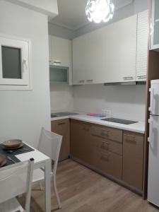 uma cozinha com uma mesa e um frigorífico branco em Studio NATASHA in the area of Kallithea em Atenas