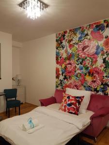 a room with a bed with a flower mural on the wall at Paradise Apartman in Miskolc