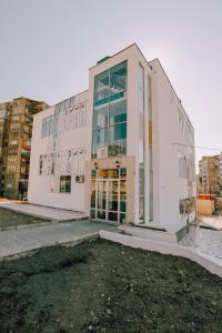 un grand bâtiment blanc avec des portes en verre dans une ville dans l'établissement SResidence, à Tbilissi