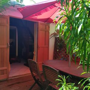 una mesa con una sombrilla rosa en el patio en T3 Duplex Meublé Lagon Réunion, en La Saline-Les-Bains