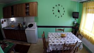 een keuken met een tafel en een klok aan de muur bij Apartment Roxana Vrdnik in Vrdnik