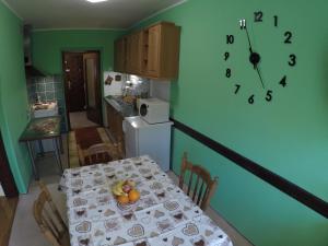 een keuken met een tafel en een klok aan de muur bij Apartment Roxana Vrdnik in Vrdnik +11 foto's