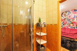 a bathroom with a shower and a red couch at Paradise Apartman in Miskolc