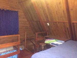 a bedroom with a bed and a desk in a cabin at Casa de descanso in Colonia Estrella