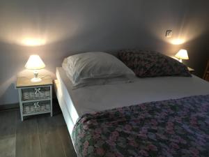 a bedroom with a bed and a night stand with two lamps at La maussanaise in Maussane-les-Alpilles