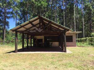 a pavilion with a wooden roof in a field at Casa de descanso in Colonia Estrella