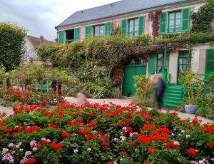 a house with a garden of flowers in front of it at La maison des pêcheurs in Saint-Pierre-du-Vauvray