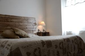 een slaapkamer met een bed met een houten hoofdeinde bij Agriturismo dei Legi in San Pietro Vara