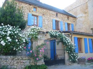 a stone house with a gate with flowers on it at Chateau Cottage in Carlux