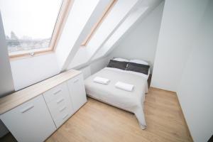 ポラニツァ・ズドルイにあるMS-APART Apartament Sudety 2-Poziomowyの白いベッドルーム(ベッド1台、窓付)
