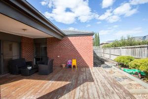 a patio with chairs and a brick wall at Holiday Rose in Point Cook