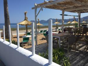 ソン・セッラ・デ・マリーナにあるCasa Mar a 2 MIN de la Playa Son Serra de Marinaのビーチ(テーブル、椅子、パラソル付)