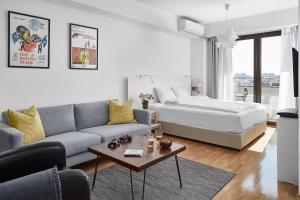 een woonkamer met een bank en een bed bij Moodeight Apartments in Skopje