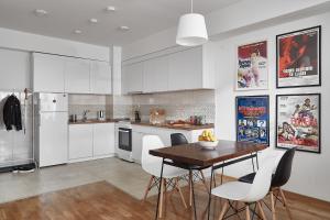 a kitchen with white cabinets and a table and chairs at Moodeight Apartments in Skopje