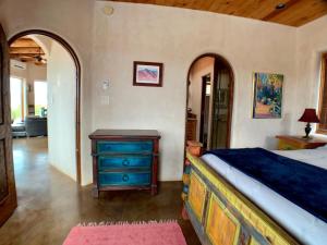 a bedroom with a bed and a dresser in a room at The Casita del Lago in Abiquiu