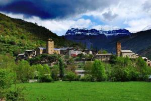 una pequeña ciudad en una colina con un campo verde en Casa Herrero, en Oto