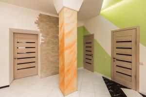 een kamer met groene en witte muren en houten deuren bij AVANGARD Green Park Apart in Lviv