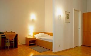 ein Schlafzimmer mit einem Bett, einem Schreibtisch und einem Tisch in der Unterkunft Hotel zum Scheppen Eck in Wiesbaden