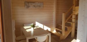 Habitación de madera con mesa, sillas y escalera en Domki Morskie Opowieści en Nickelswalde