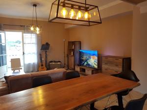 a living room with a wooden table and a television at Mojo modern apartment 2 in Alikanas