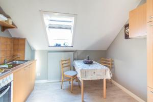 a kitchen with a table with chairs and a window at Orchidee in Niebüll