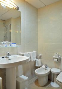 
a bathroom with two sinks and a toilet at Hotel Caballo de Oro in Benidorm
