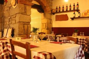 a dining room with tables and chairs with wine bottles at Antica Locanda La Posta in Gaggio Montano +28 photos