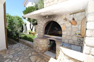 a stone pizza oven in a yard with a patio at Apartments Dvorski in Mandre