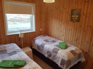 a room with two beds and a window in it at Silva Holiday Home in Eyjafjaroarsveit