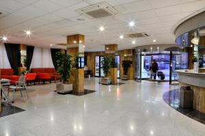un vestíbulo con sillas y mesas en un edificio en Hotel Caballo de Oro, en Benidorm