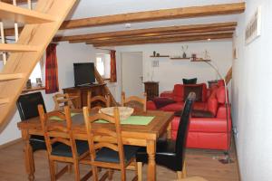 una sala da pranzo con tavolo e divano rosso di Ferienwohnung Altstadtidylle 2 a Wernigerode