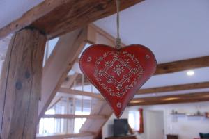 a red heart hanging from a wooden ceiling at Ferienwohnung Altstadtidylle 2 in Wernigerode
