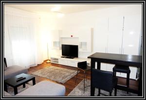 een woonkamer met een tafel en een televisie bij Sankt Veit Apartment in Sankt Veit an der Glan