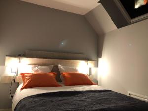 a bedroom with a large bed with orange pillows at Gîte de la Huppe in Noyers-sur-Cher