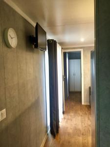 un couloir avec une horloge sur le mur et une porte dans l'établissement FISHKA HOUSE Domek wypoczynkowy, à Zator