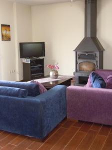 a living room with two purple couches and a fireplace at Majia 2 bedroom apartment in Gerani