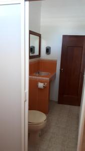 ein Badezimmer mit Toilette, Waschbecken und Spiegel in der Unterkunft Hotel Alebrijes in San Pedro Pochutla