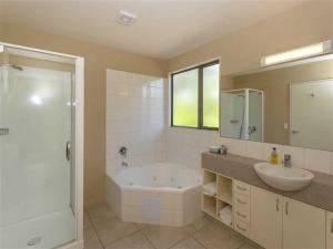 a bathroom with a tub and a sink and a shower at Vintners Retreat in Blenheim