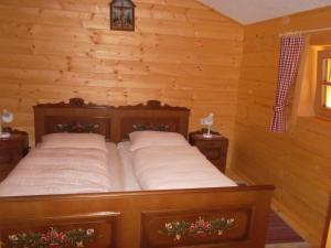 een slaapkamer met een bed in een blokhut bij Riepleralm in Matrei in Osttirol