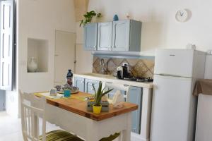 a kitchen with a table and a white refrigerator at Casa Mida - Guest House in Pezze di Greco