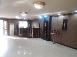 a lobby with a man standing at a bar at Toshkent Hotel in Andijan
